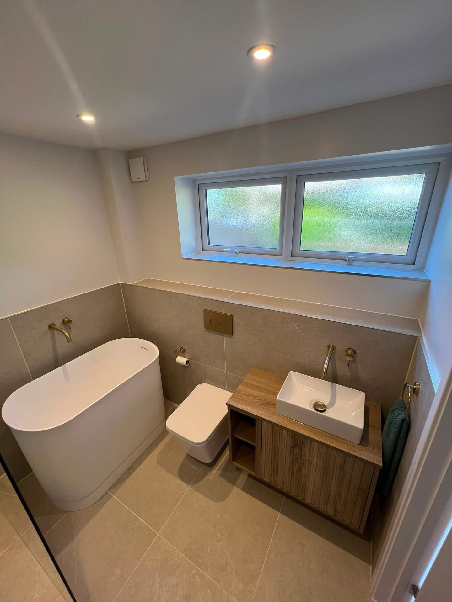 Modern bathroom with freestanding bath and wooden vanity